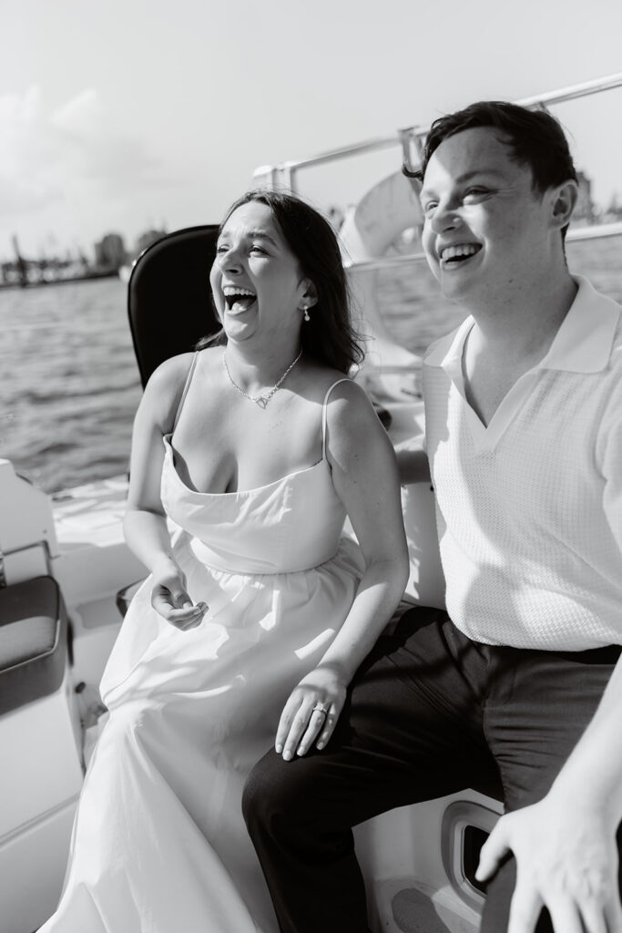 A couple sharing a sweet moment during a surprise sailboat proposal at sea.
