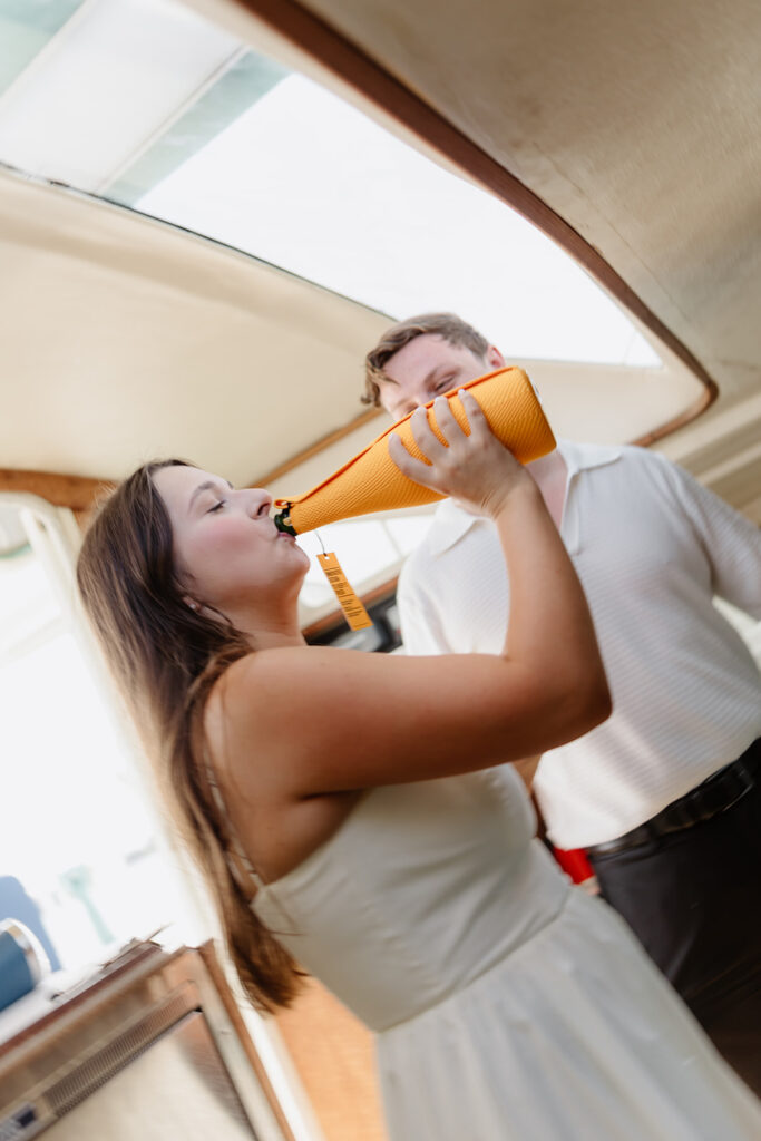 A couple sharing a sweet moment during a surprise sailboat proposal at sea.
