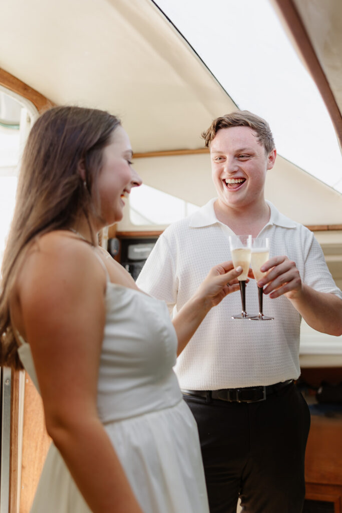 A couple sharing a sweet moment during a surprise sailboat proposal at sea.
