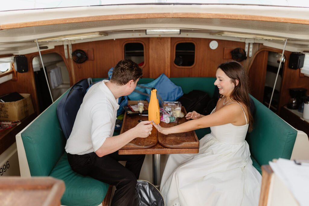 A romantic sailboat proposal captured with the couple posing together on deck.