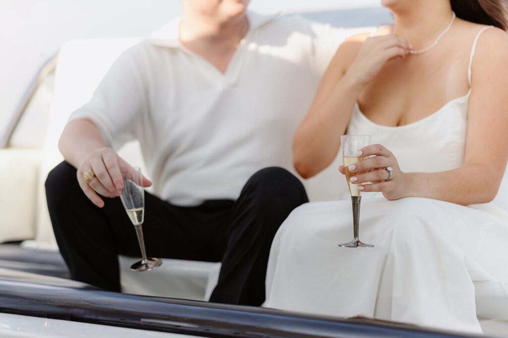 A pair standing together on a sailboat, celebrating their romantic surprise proposal.
