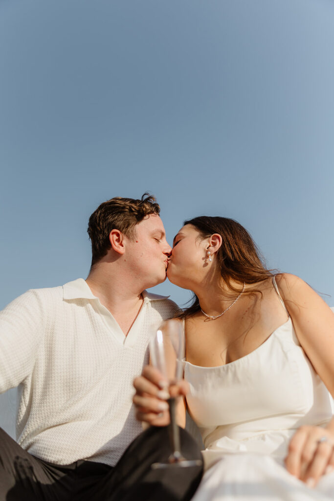 A couple sharing a sweet moment during a surprise sailboat proposal at sea.
