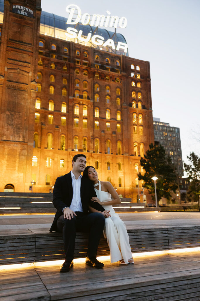 A couple enjoying a quiet, intimate engagement session at Domino Park in Brooklyn, framed by the dreamy blue hour glow.
