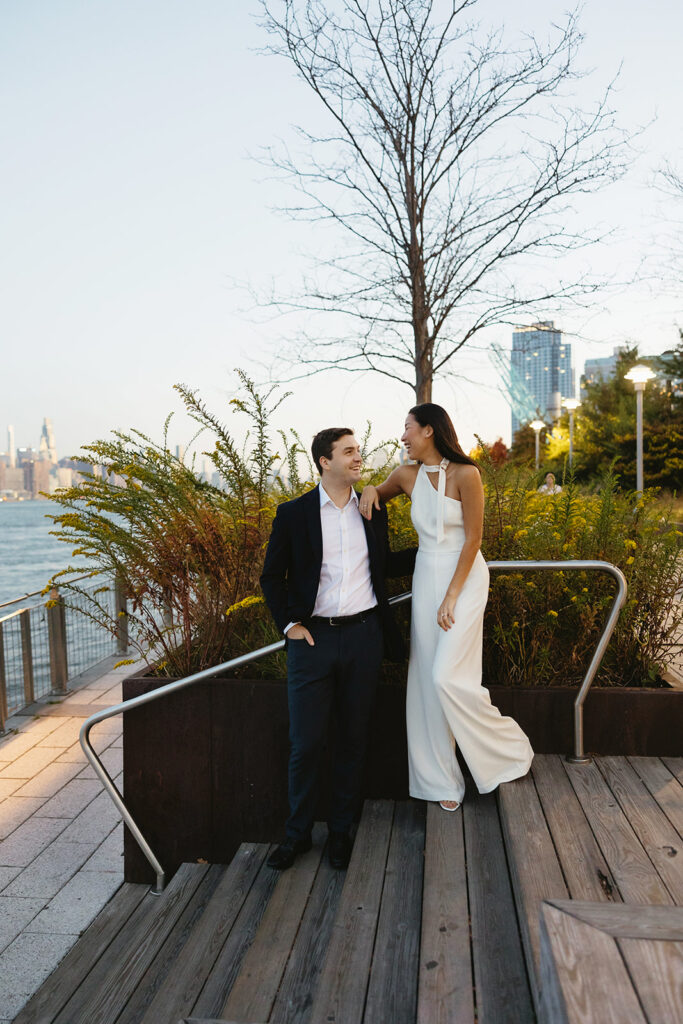 A couple sharing romantic moments during their early morning engagement session at Domino Park, Brooklyn, with the soft blue hour light setting the scene.
