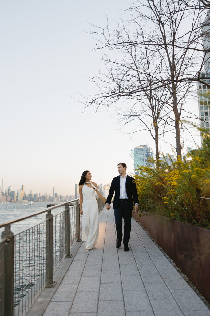 A couple sharing romantic moments during their early morning engagement session at Domino Park, Brooklyn, with the soft blue hour light setting the scene.
