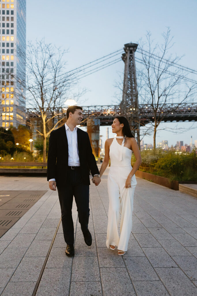 A couple enjoying a quiet, intimate engagement session at Domino Park in Brooklyn, framed by the dreamy blue hour glow.
