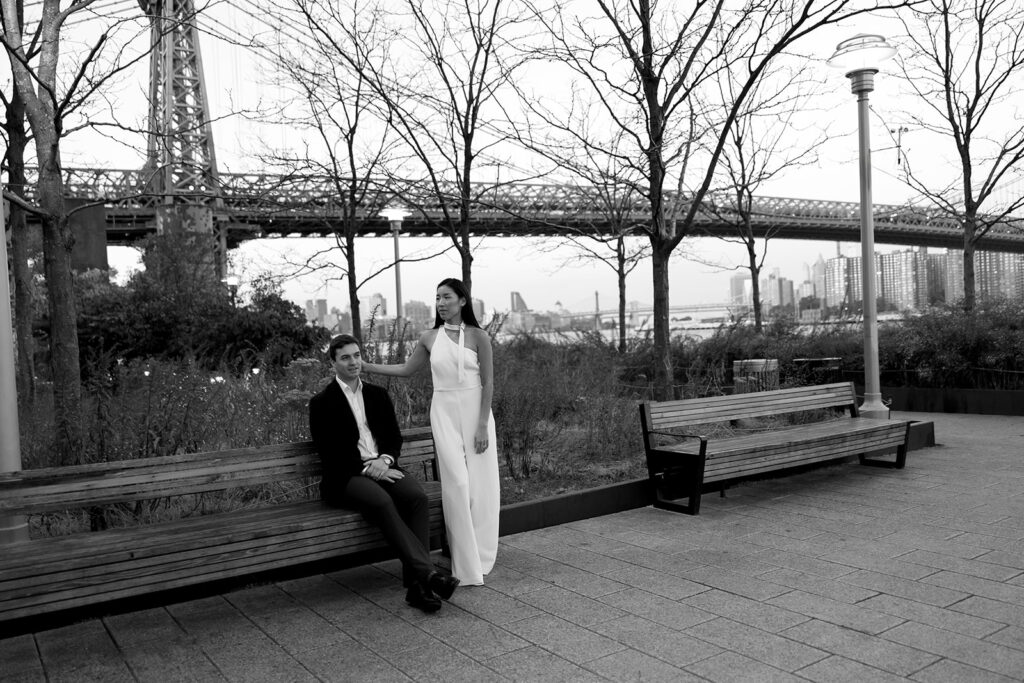 A pair embracing at Domino Park in Brooklyn during their sunrise engagement shoot, surrounded by a calm, pre-dawn atmosphere.
