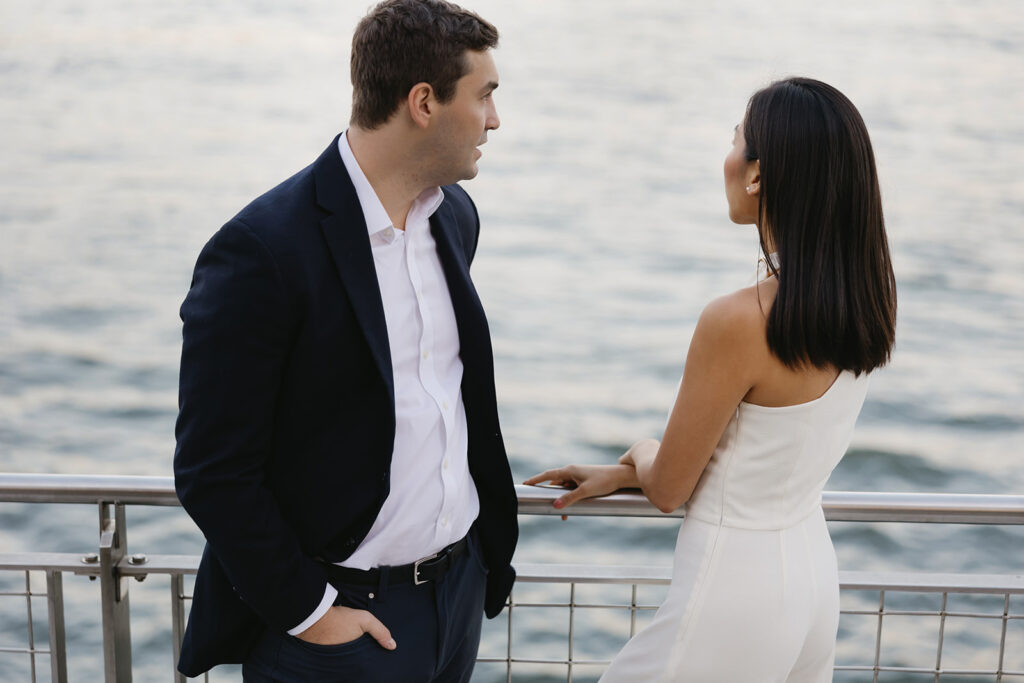 A pair embracing at Domino Park in Brooklyn during their sunrise engagement shoot, surrounded by a calm, pre-dawn atmosphere.
