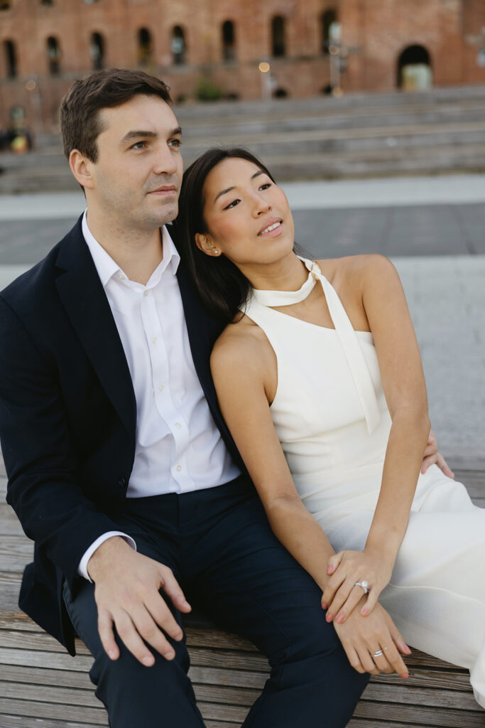 A couple enjoying a quiet, intimate engagement session at Domino Park in Brooklyn, framed by the dreamy blue hour glow.
