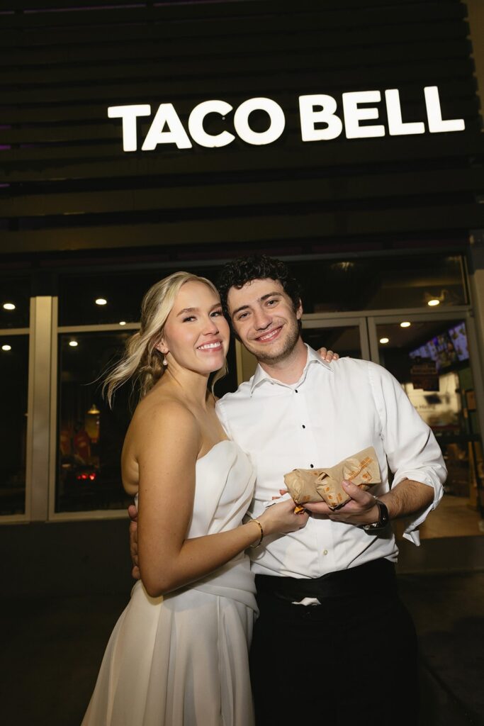 bride and groom posing outside of taco bell