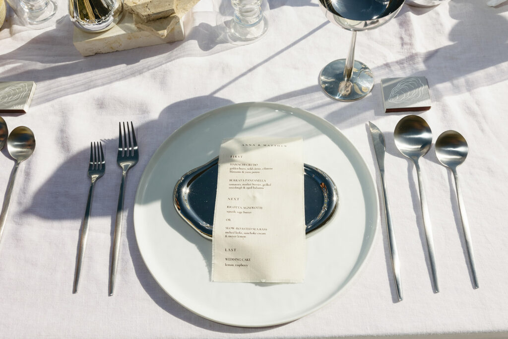 Chic seaside wedding reception design featuring minimal florals and polished accents
