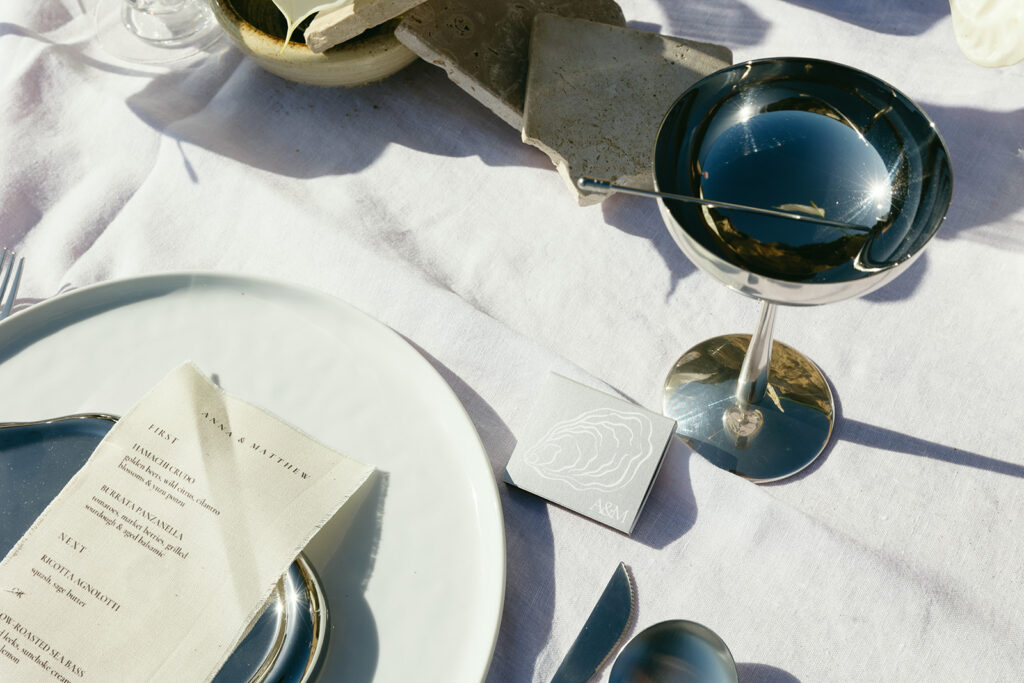 Chic seaside wedding reception design featuring minimal florals and polished accents
