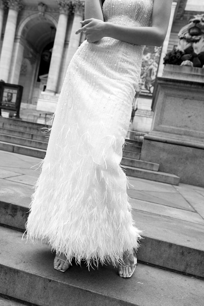Bride standing on the steps of the New York Public Library in a wedding dress
