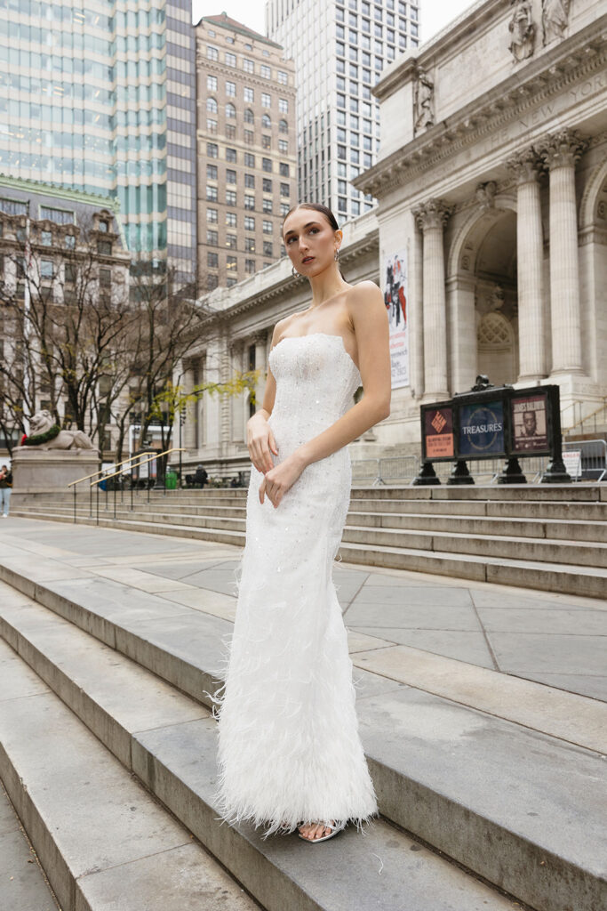 Bride standing on the steps of the New York Public Library in a wedding dress
