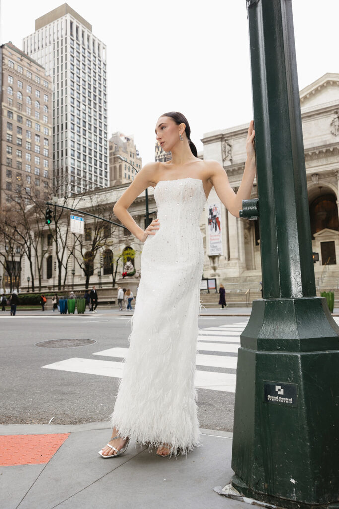Bride standing on the steps of the New York Public Library in a wedding dress
