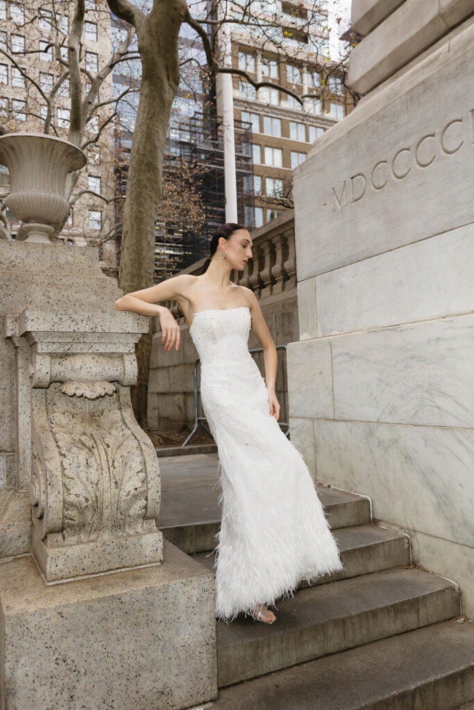 Bride standing on the steps of the New York Public Library in a wedding dress
