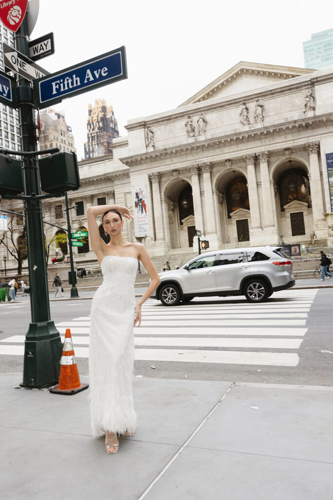 Bride standing on the steps of the New York Public Library in a wedding dress
