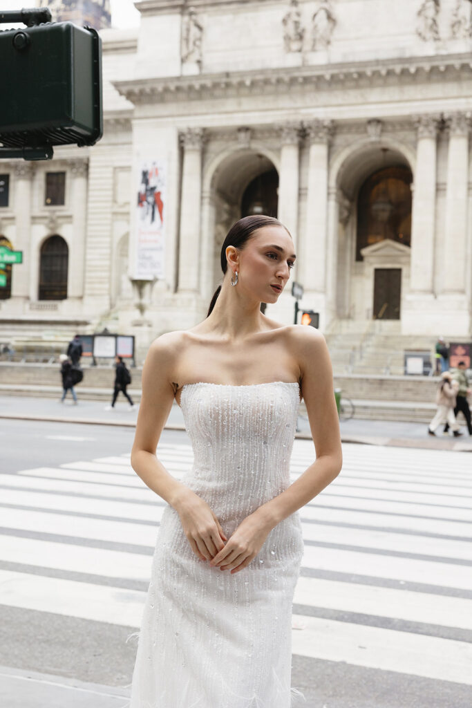 Bride standing on the steps of the New York Public Library in a wedding dress
